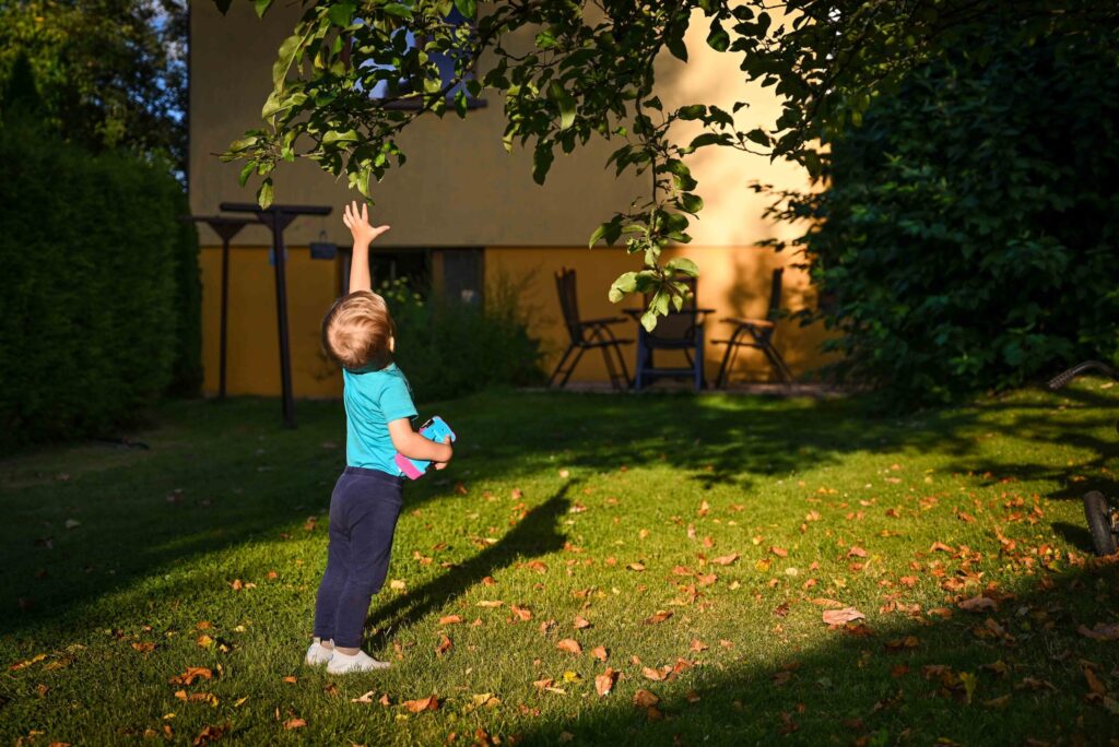 rodinné fotenie chlapec sa hrá na dvore pri západe slnka